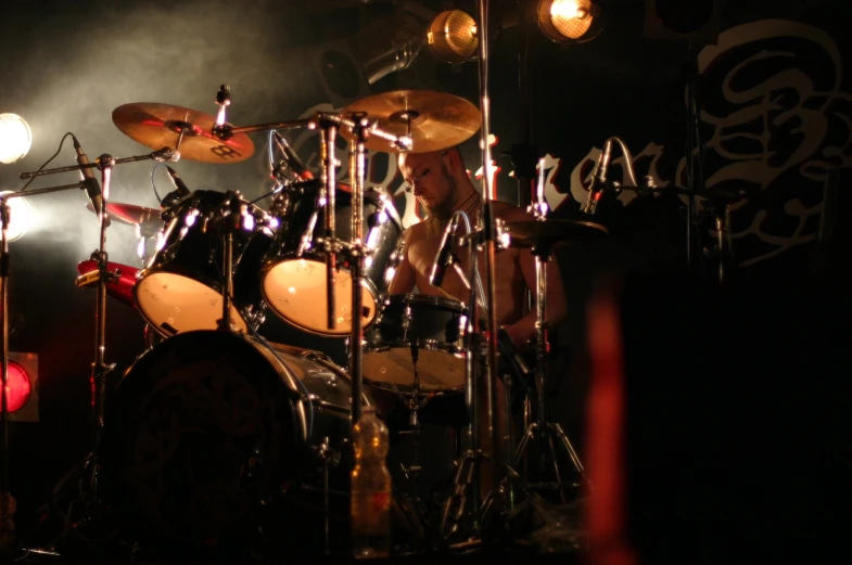 a man in the middle of his drumming set playing