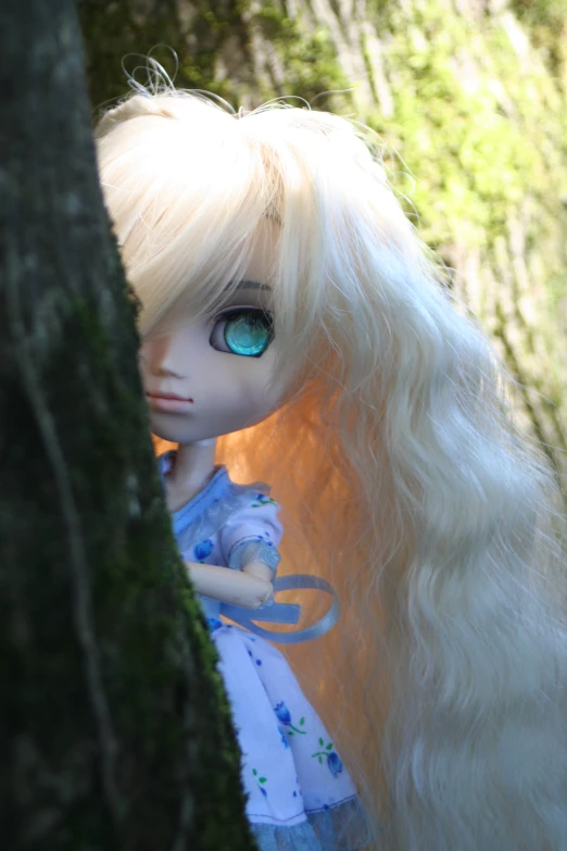 a doll is sitting in the woods with a tree
