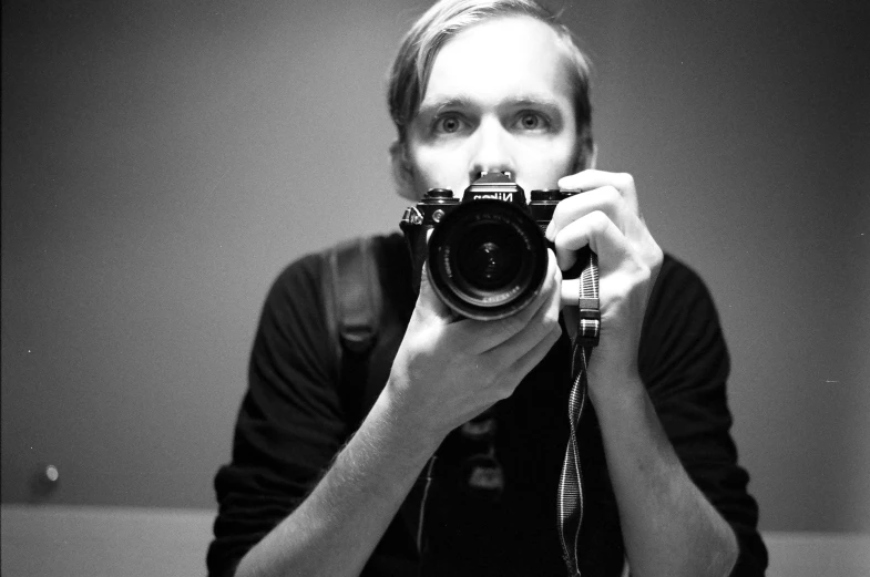 a black and white po of a person holding a camera