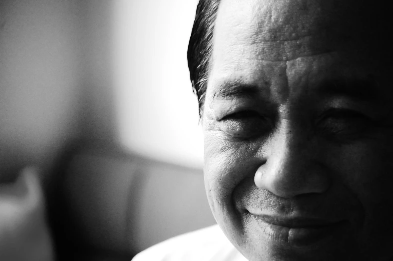 a man in a white shirt smiling and looking up