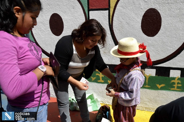 two girls near two woman who are dressed in a hat