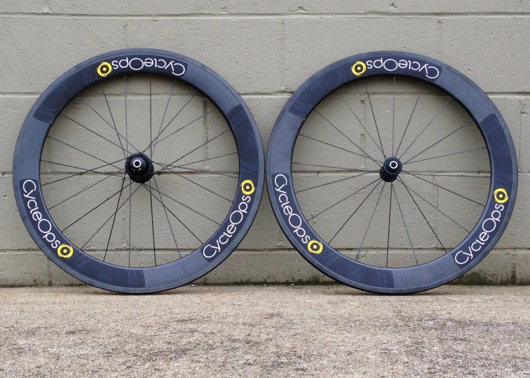 two blue wheels sitting side by side in front of a grey wall