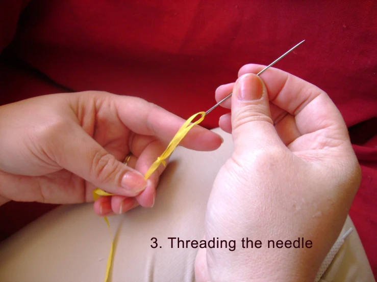 a person is working with thread while holding a needle