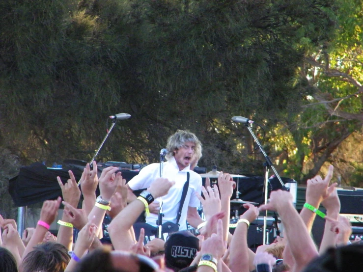 man standing on stage while he is surrounded by fans