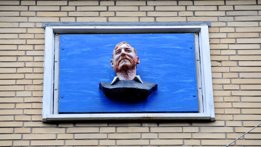 a fake face is attached to a brick building