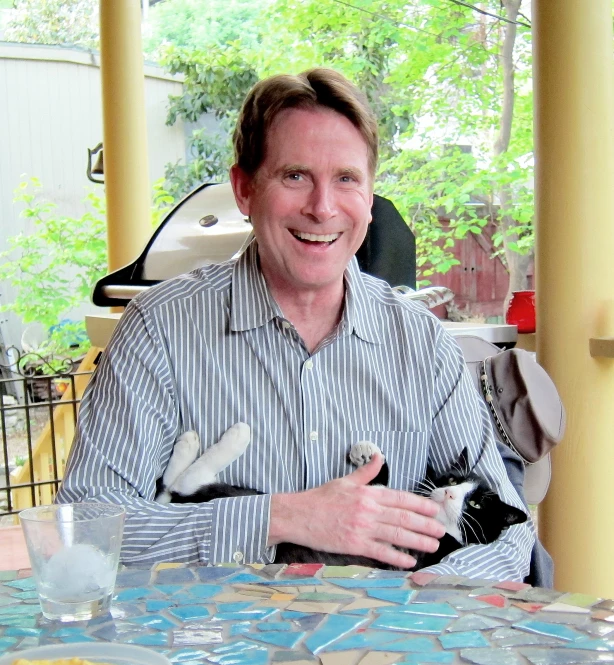 a man holding a small black and white dog