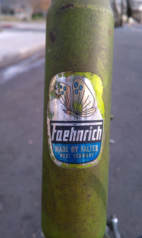 a sticker is attached to a green pole