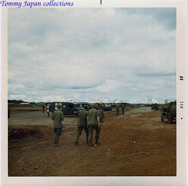 the picture shows several army officers walking toward trucks