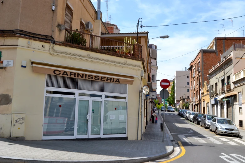 the narrow city is lined with cars parked along it