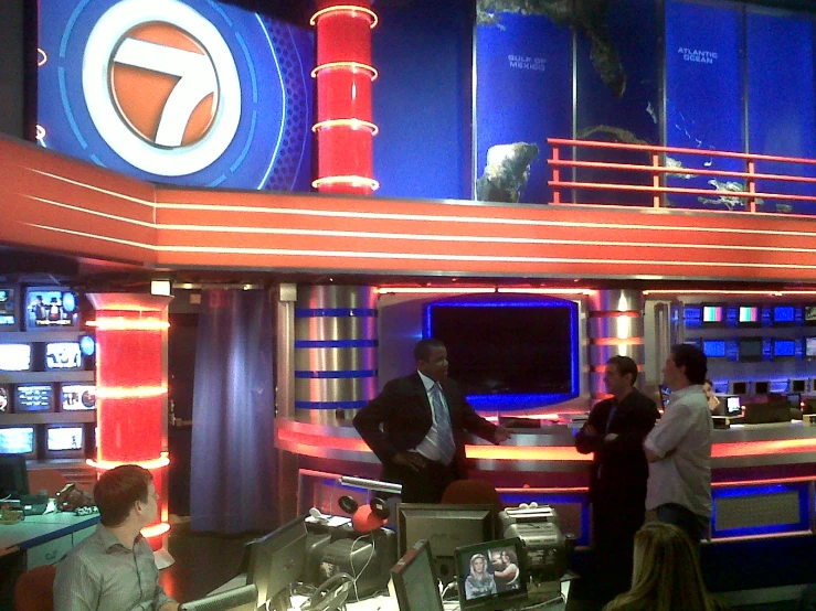 two people on tv set with three people in the studio