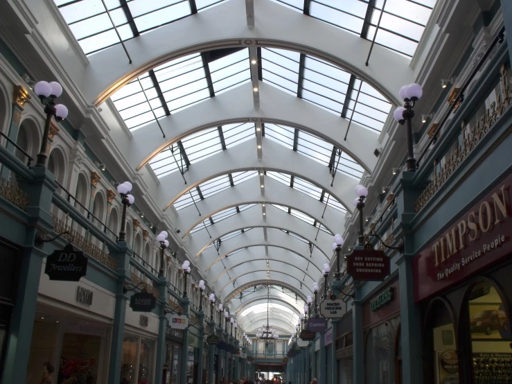 several people are walking down an empty shopping mall