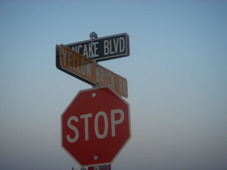 two street signs, one showing street names and the other indicating stop