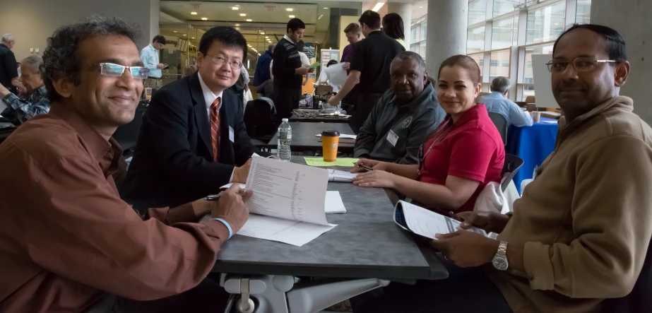 three men and two women smile for the camera