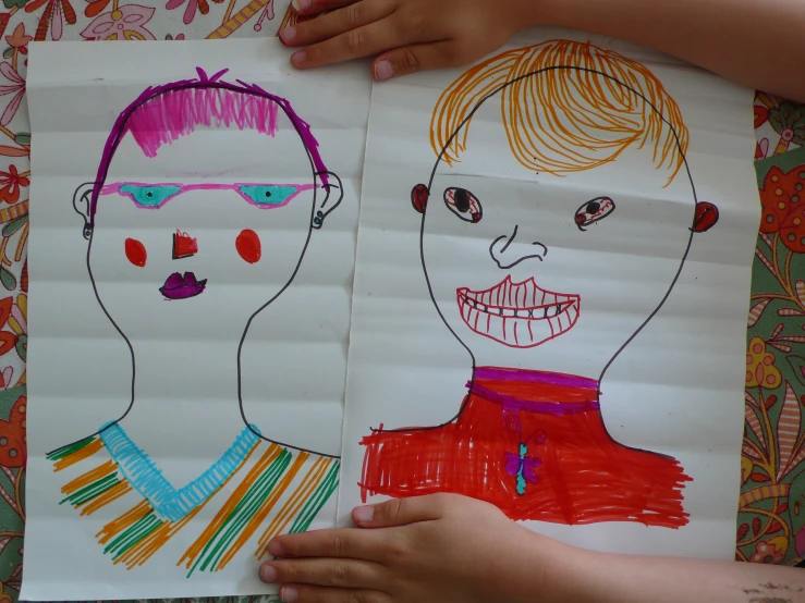 child's artwork in their hands of two children