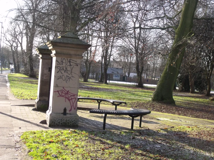 a bench with spray painted graffiti in a park