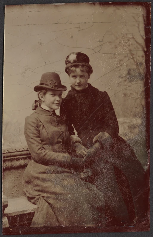 two young children, dressed in old fashioned clothes, are standing together