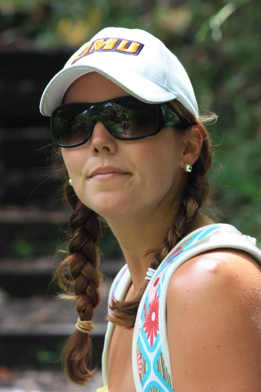 a woman wearing a cap and sun glasses