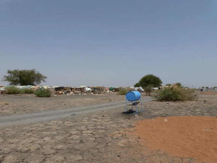 a small car in the dirt parked next to a gravel road