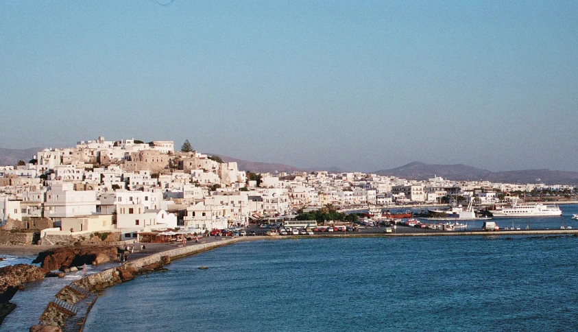 an aerial view of several white buildings by the water