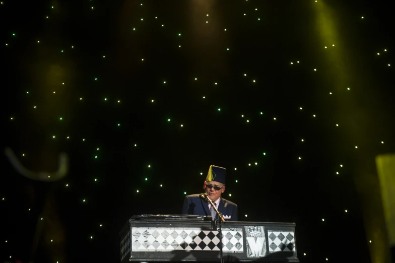 a man on a keyboard playing music with lights around him