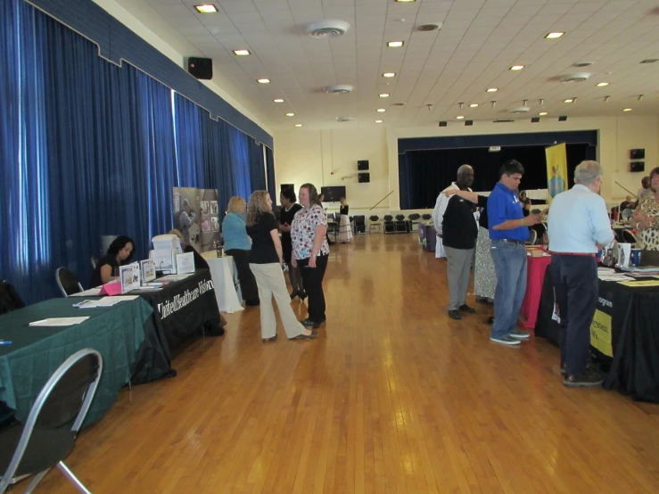 there are many people in the ballroom near tables