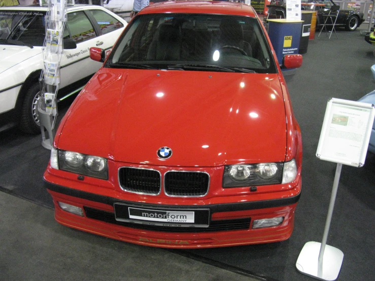 a red car sitting on top of a black floor