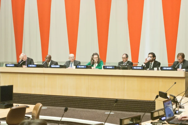 several people sit at tables in a meeting