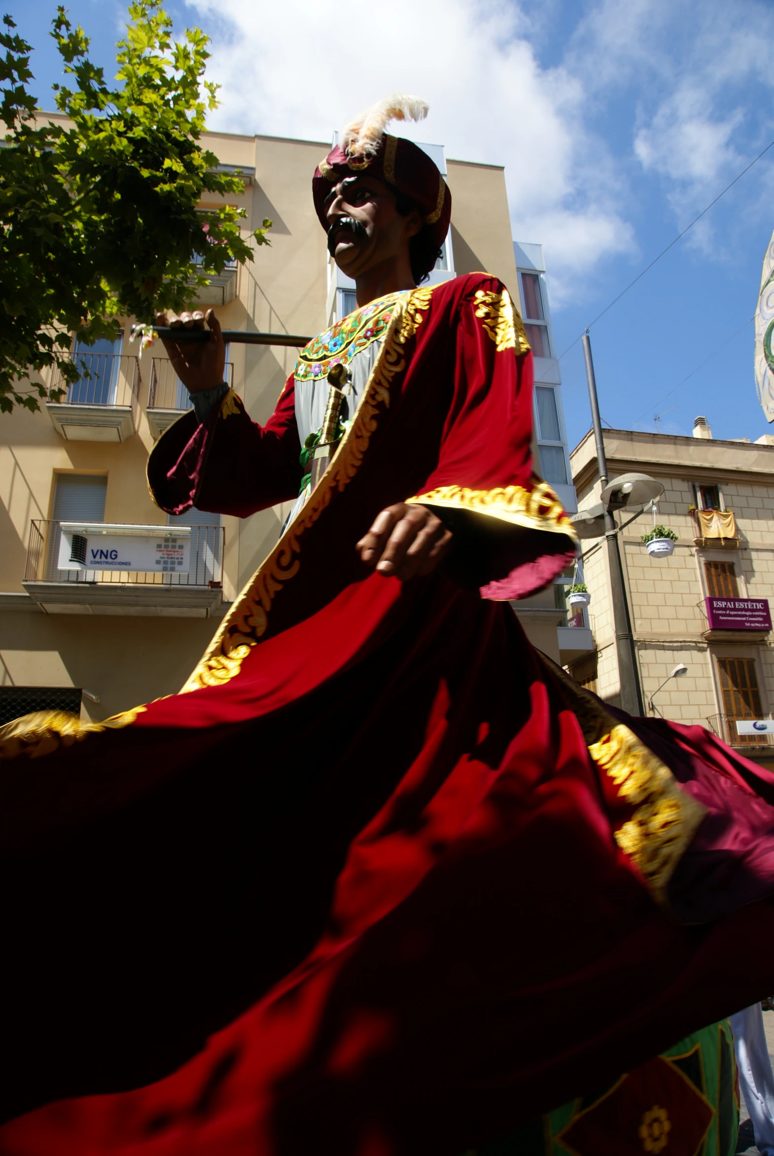 a large black face painted in bright red and gold robes