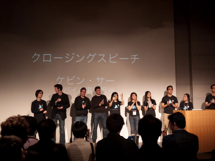 several people with cell phones in front of a stage