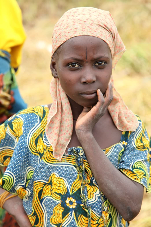 a black girl in blue and yellow shirt with a pink head scarf