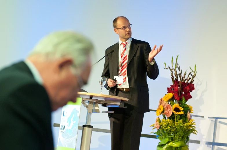 an old man standing in front of a microphone