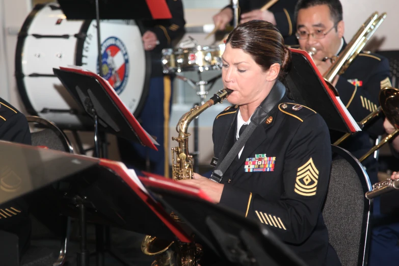 the woman in uniform is playing the instrument