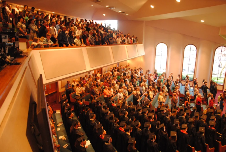 a crowd of people are inside a church watching soing