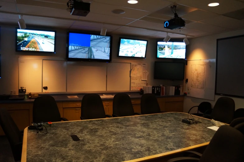 an image of a conference room setting with three tv screens