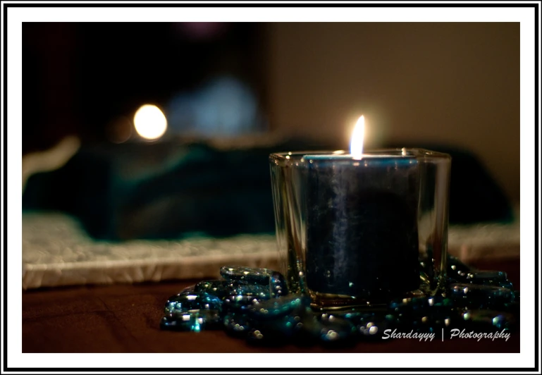 a candle in front of a small crystal beaded beads