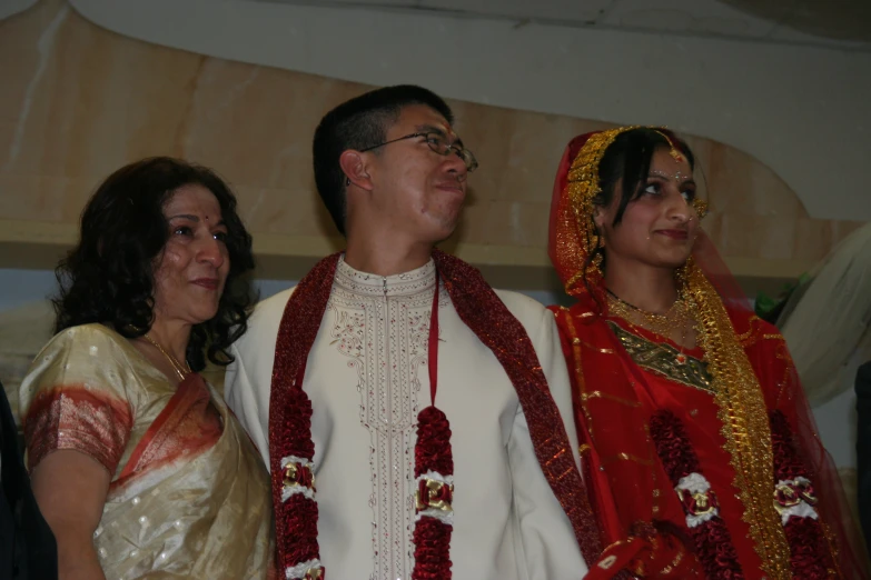 a man and two women who are dressed in ethnic wedding attire