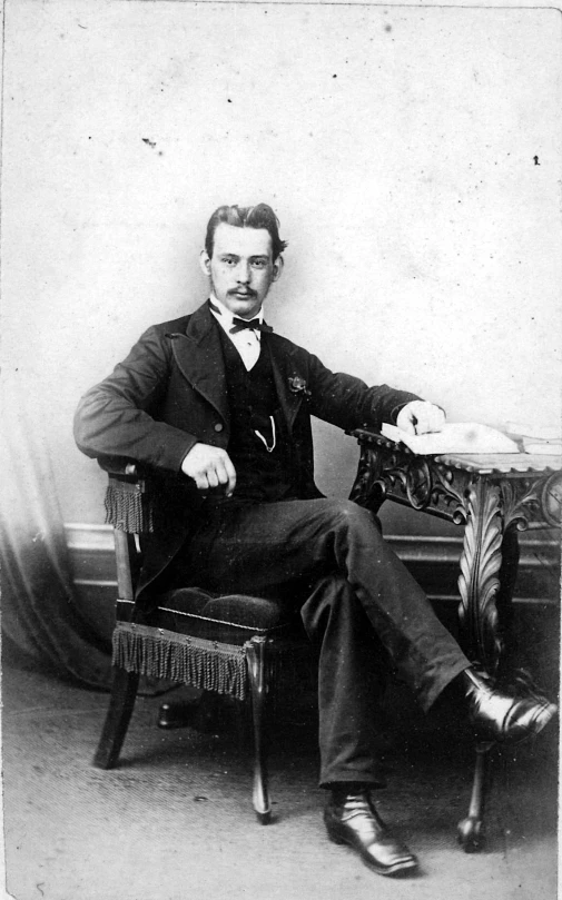 a man sitting in a chair with his arm over his leg
