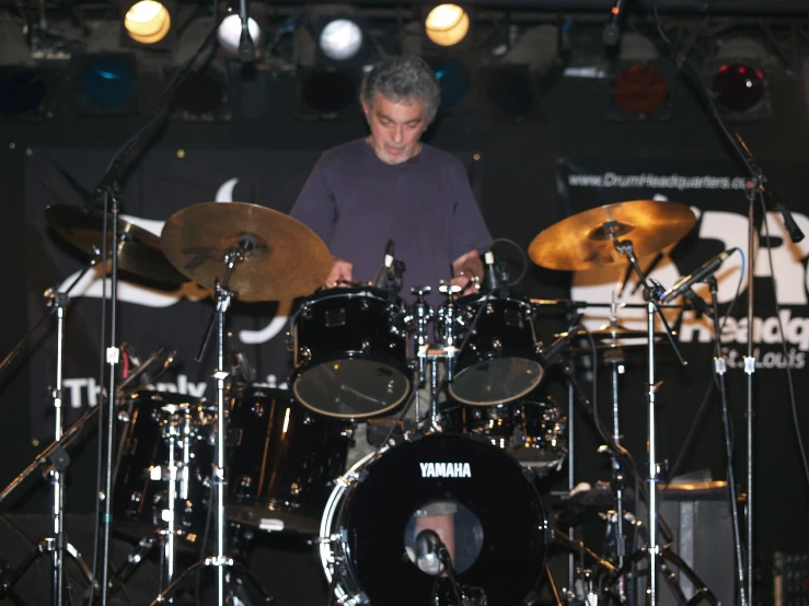 the drummer is playing his drums while listening to other performers