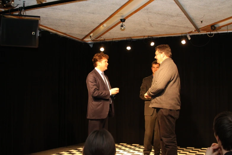 two men standing in front of a black and white checkered floor