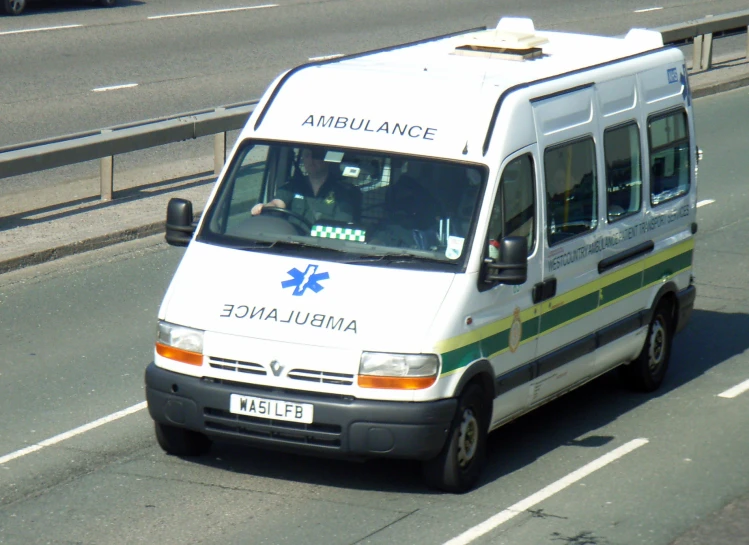 an ambulance is riding down a road with traffic