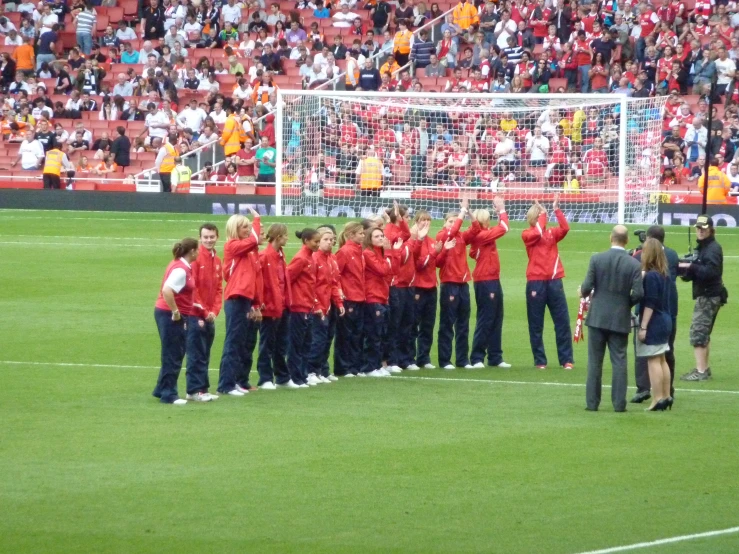 a team of women are posing on a field