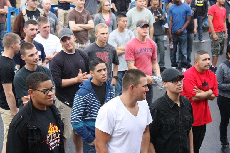 a group of people walking down a street with a man looking at another guy