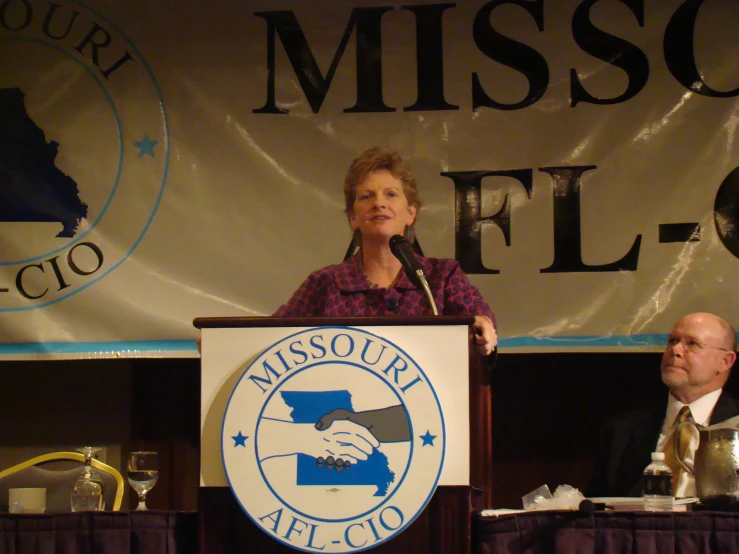 two people sitting in front of a mic to speak