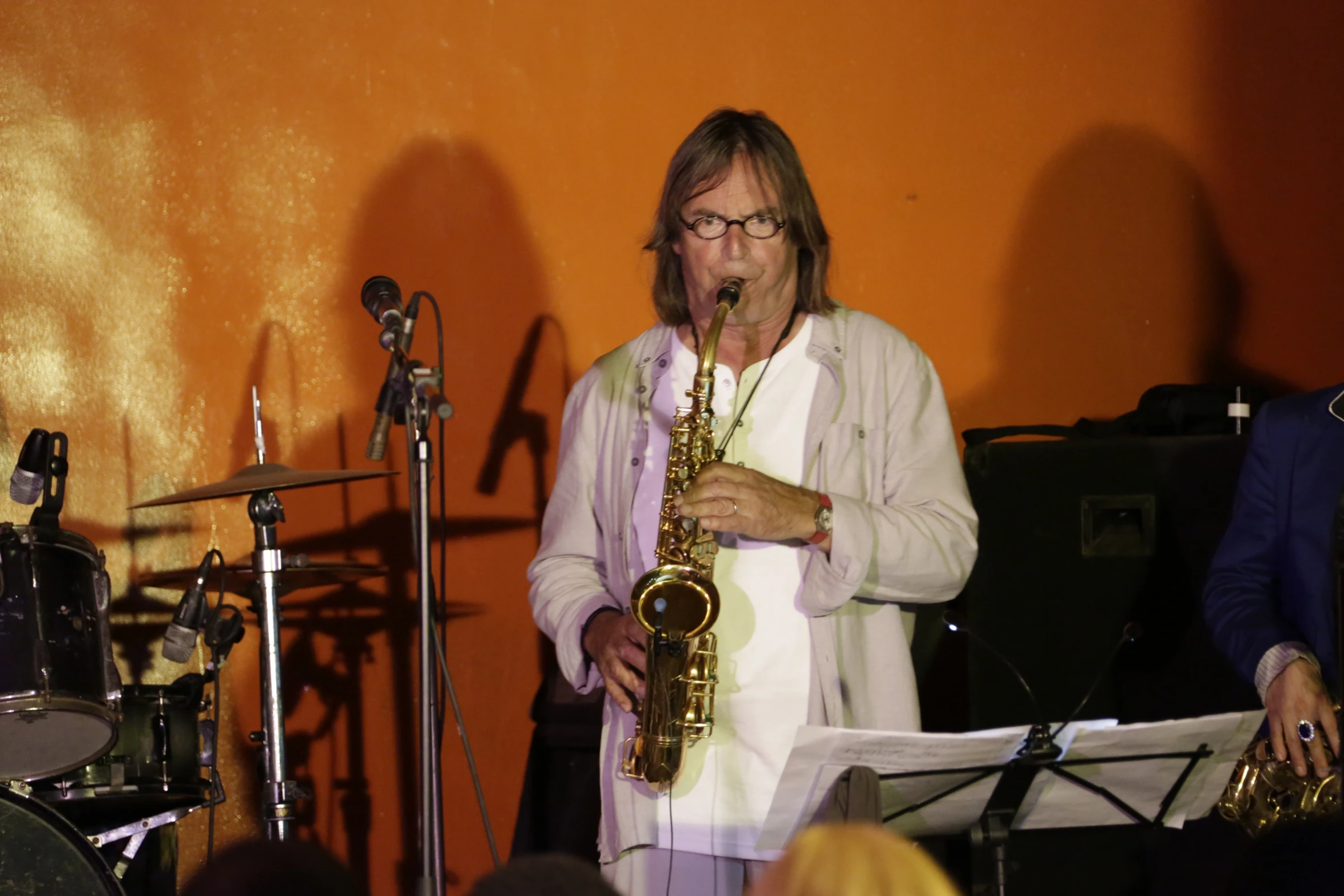 a man standing next to a saxophone in front of a microphone