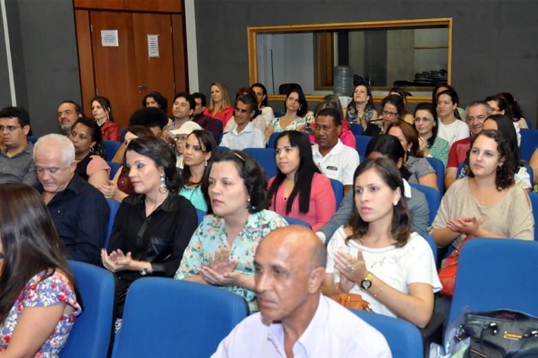 many people seated together and applauding each other