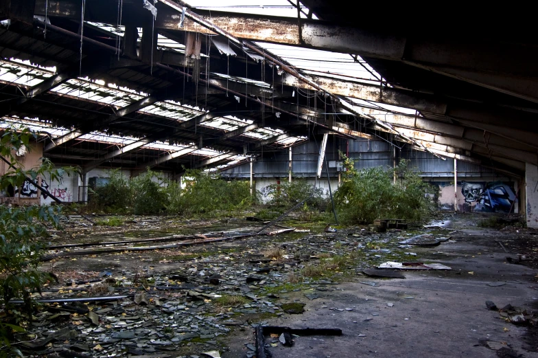 a broken building that is in disrepair, with weeds growing out of the bottom part