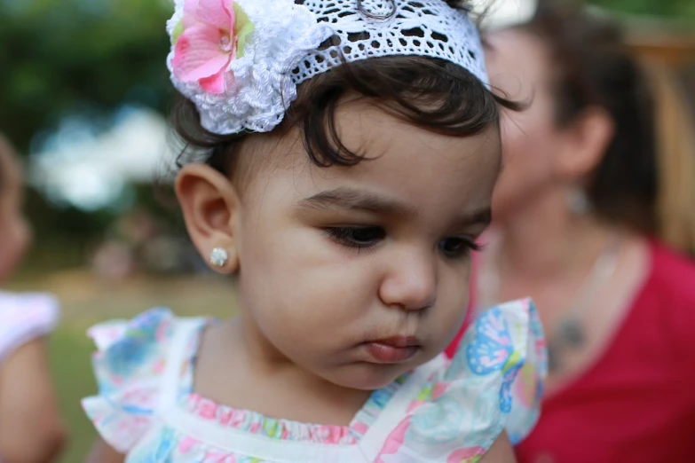 small girl in flowered dress looking down