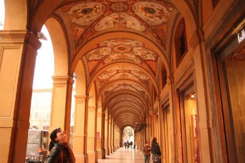 a woman standing under an archway next to other people