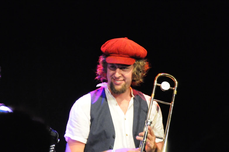 a man with red hat is playing his trumpet