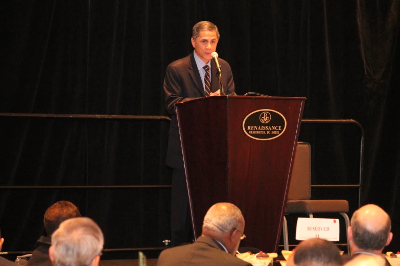 there is a man at a podium giving a presentation to an audience